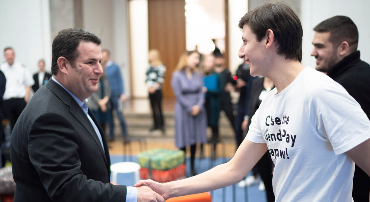 Hubertus Heil shakes hands with a young man.